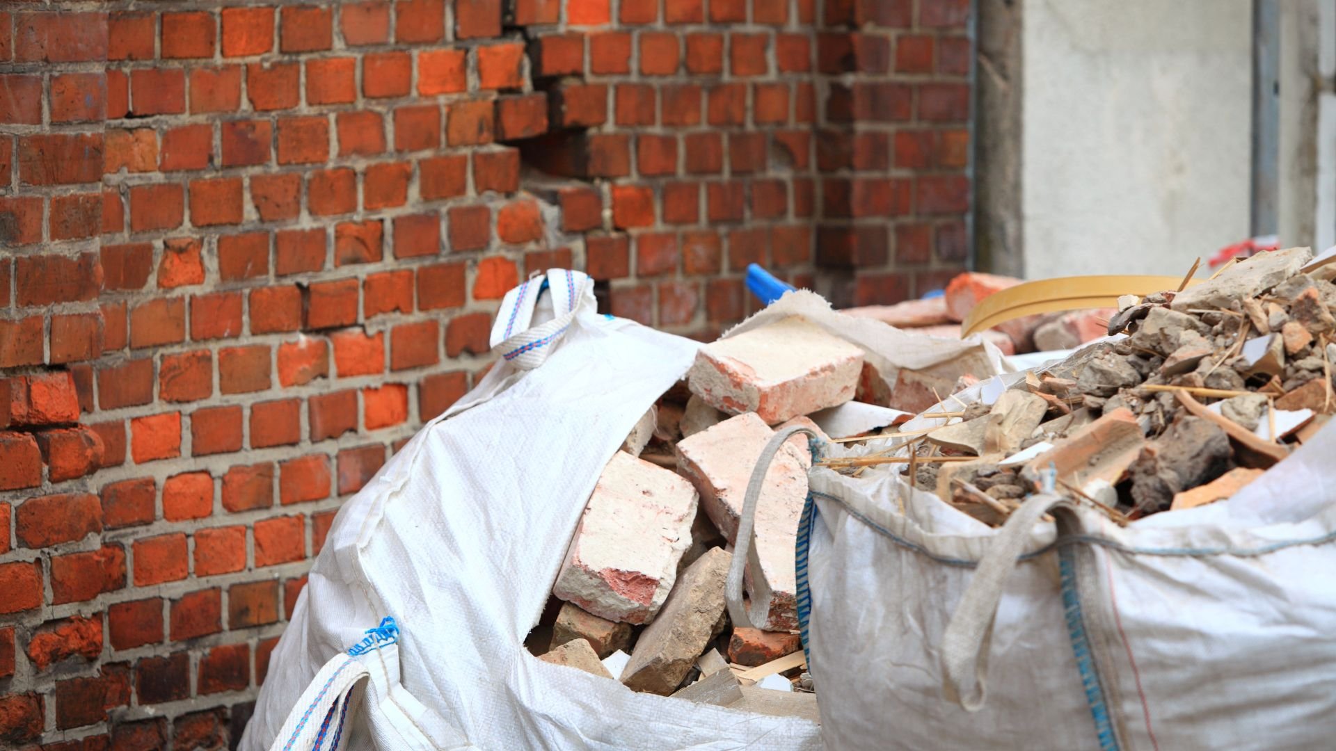 White construction bags filled with brick debris and rubble