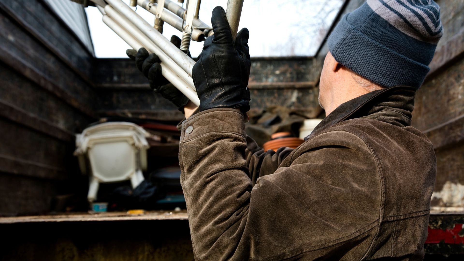 Worker in winter gear adjusting pipes in industrial or mechanical setting